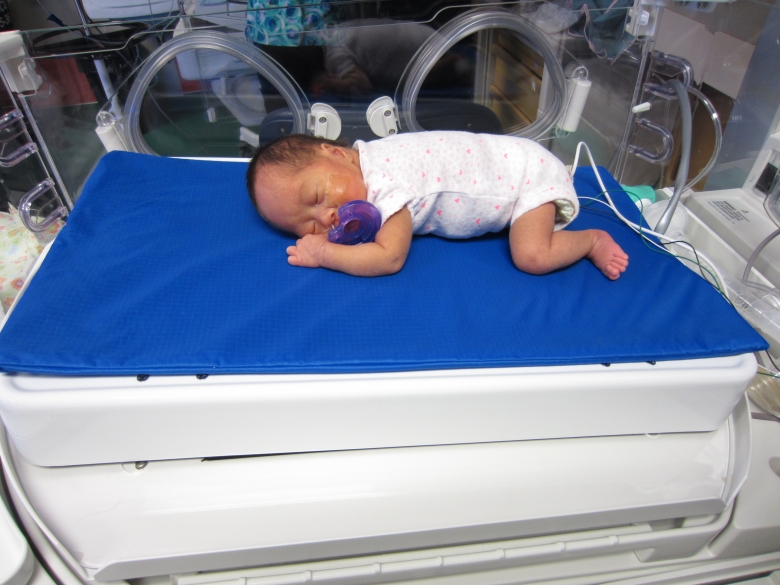 Baby lying on Calmer device in neonatal intensive care unit at BC Women's Hospital ready for testing